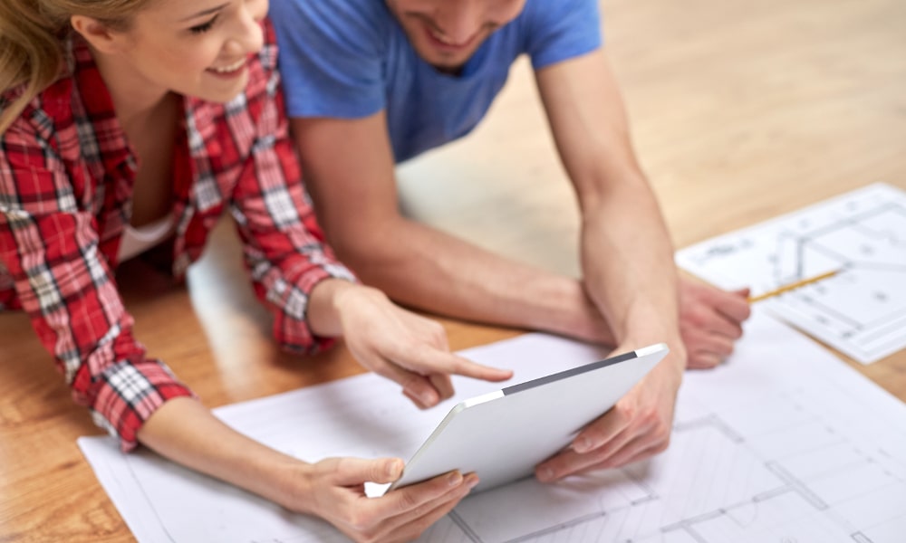 Couple looking at house plans on tablet