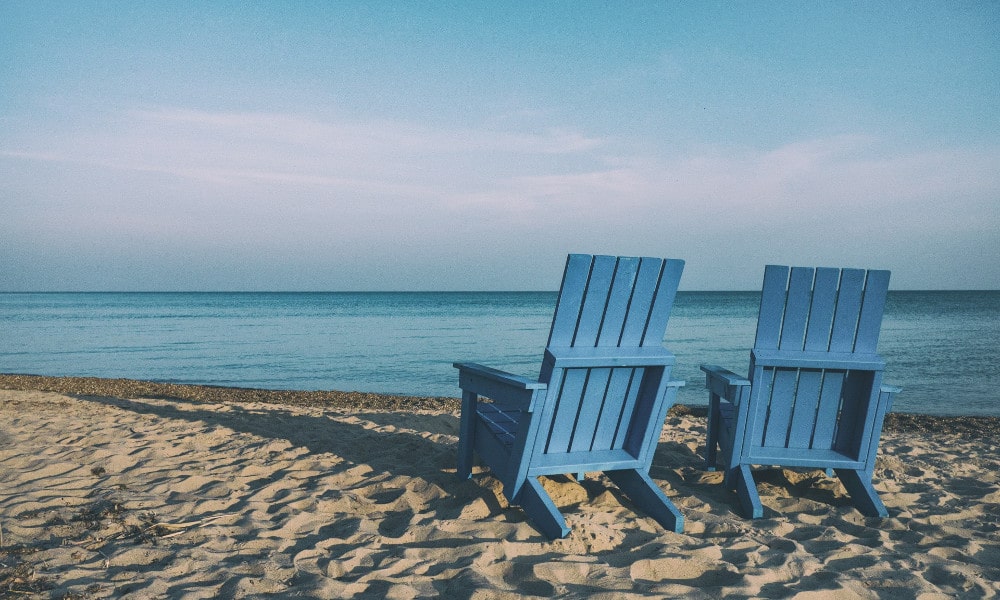Sandy beach with blue chairs